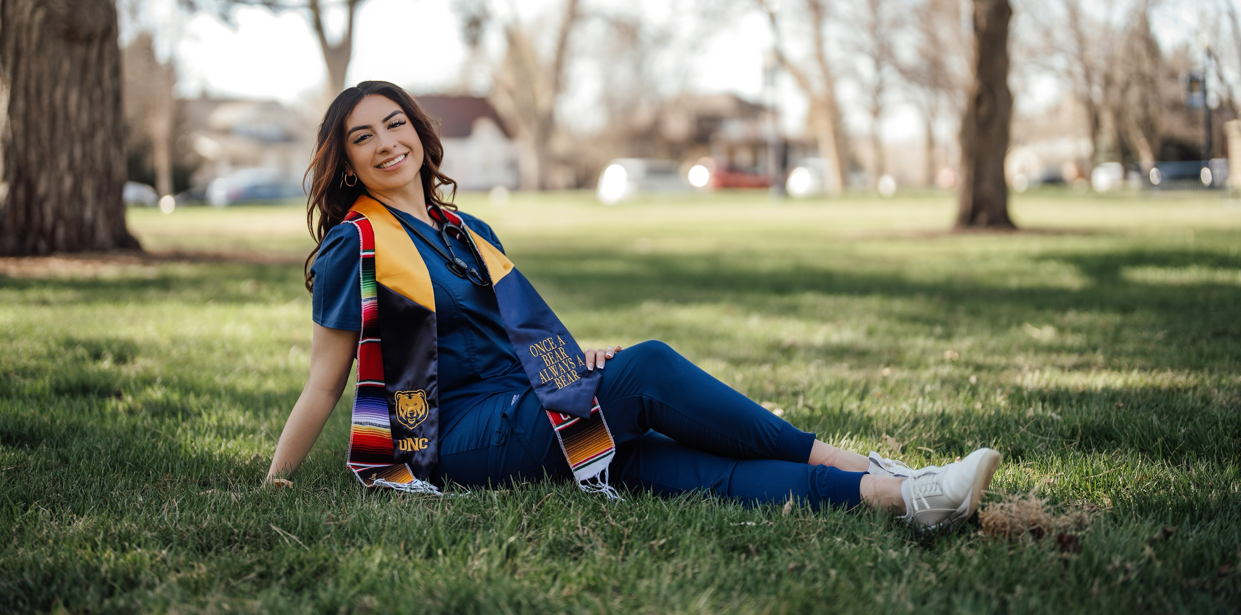 Rosemary Gonzalez sitting in nursing scrubs posing for the picture